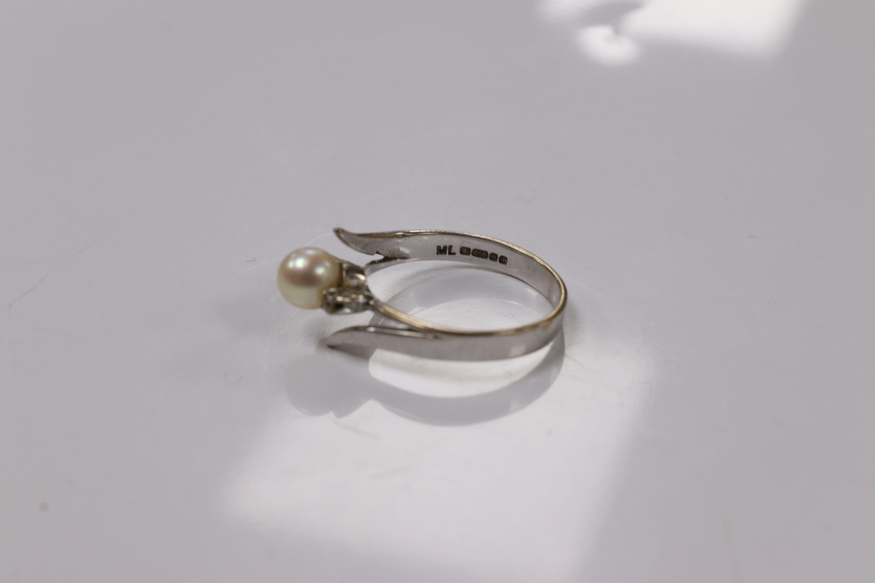 A modern 18ct white gold and single stone cultured pearl set ring, with two stone diamond set shoulders, size Q, gross weight 3.7 grams. Condition - poor to fair